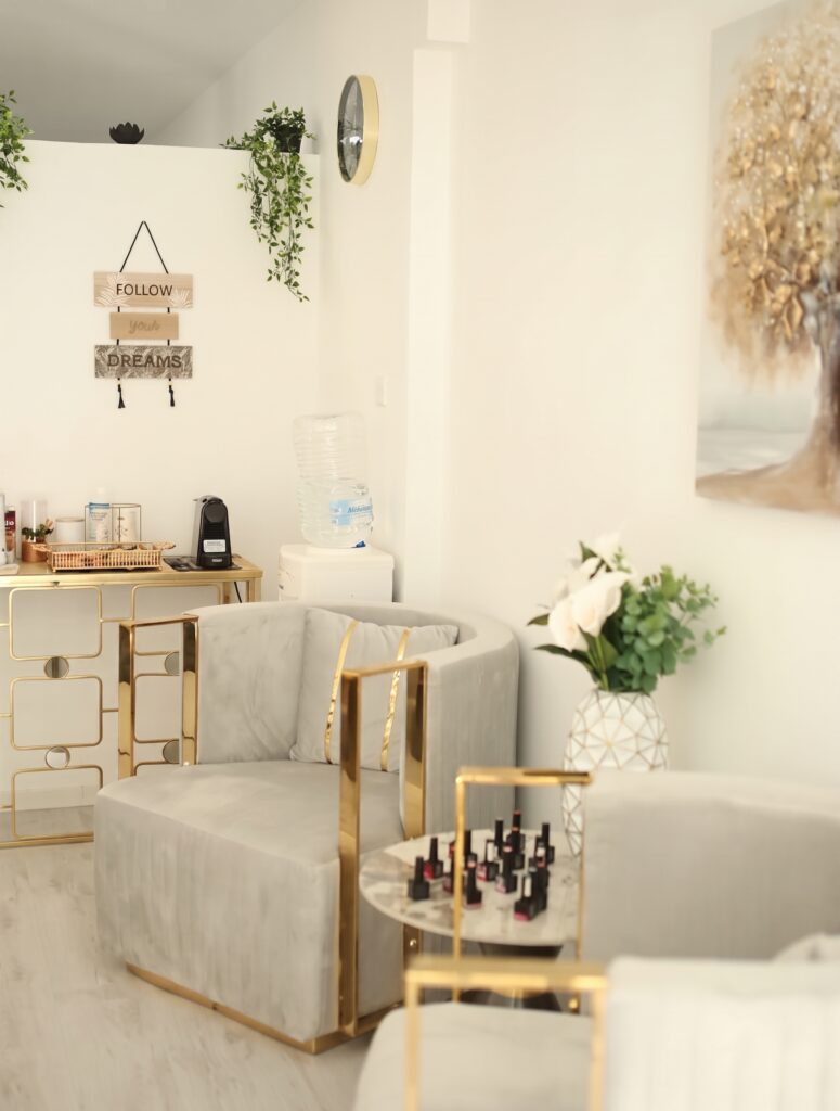 Nail bar and lounge area inside a beauty salon in Larnaca, Cyprus, with gel polish display, velvet armchairs and gold fittings
