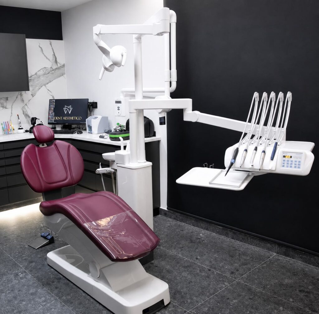 Modern dental treatment room in Larnaca with a burgundy dental chair, overhead light and digital instrument console