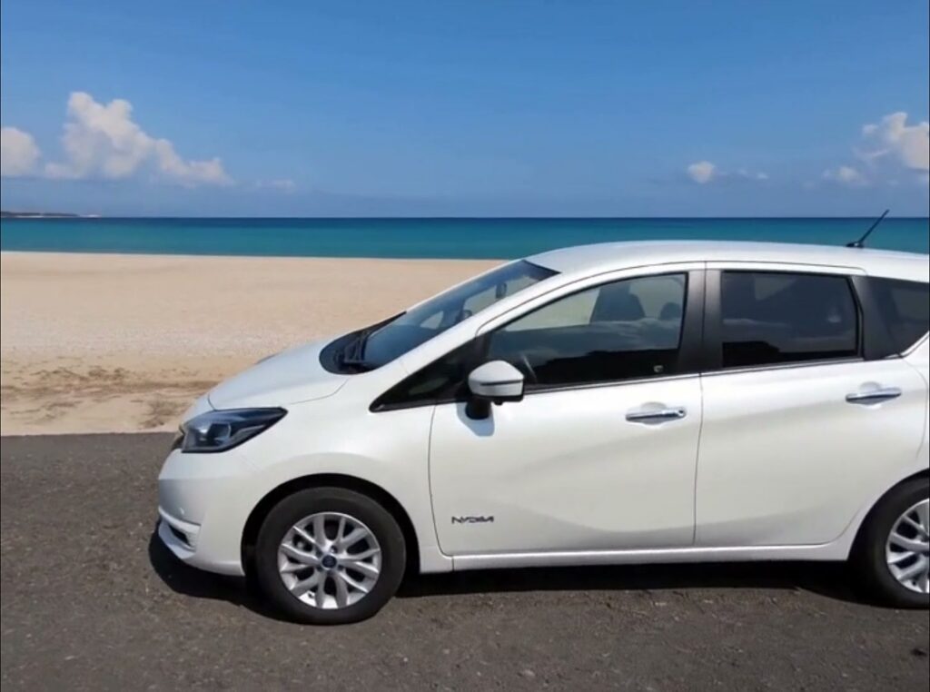 Side profile of a white Nissan Note e-POWER hybrid hire car on the Cyprus coast